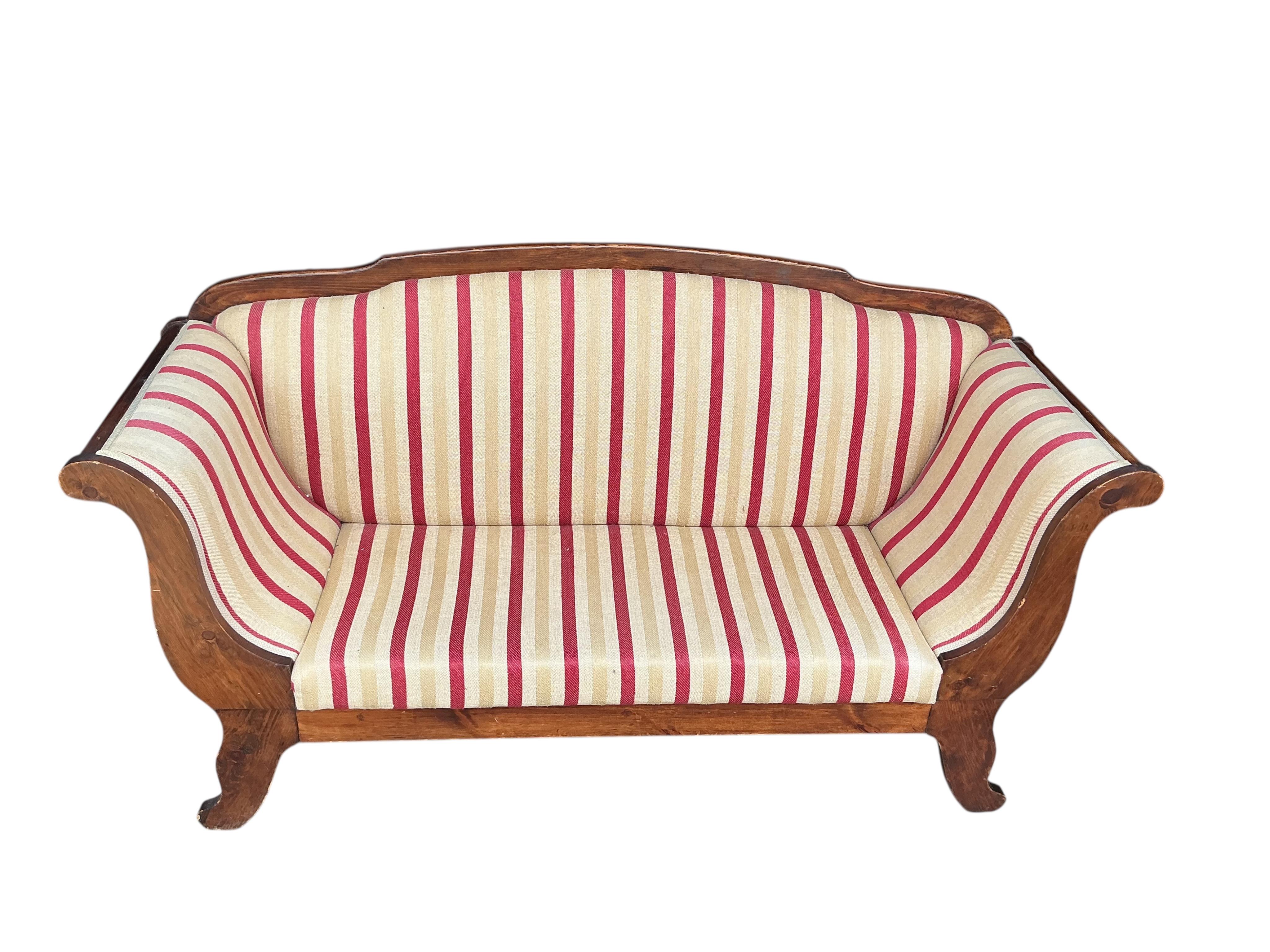 An early 19th century Continental pine scroll arm settee, width 190cm, depth 62cm, height 103cm